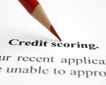 A red-tipped pencil points to the words "Credit scoring" on a document detailing an application status, offering insight into how you can boost your credit score.