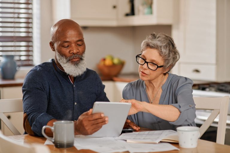 mixed race senior citizens reviewing budget