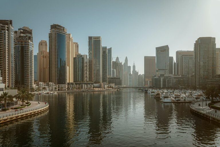 The skyline of Dubai Marina features high-rise buildings reflecting on the water, while several yachts docked along the waterfront evoke a lifestyle only achievable through careful budgeting and advice from a savvy financial planner.