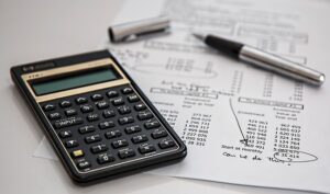 A calculator, pen, and financial documents symbolizing financial protection options and strategic financial planning.