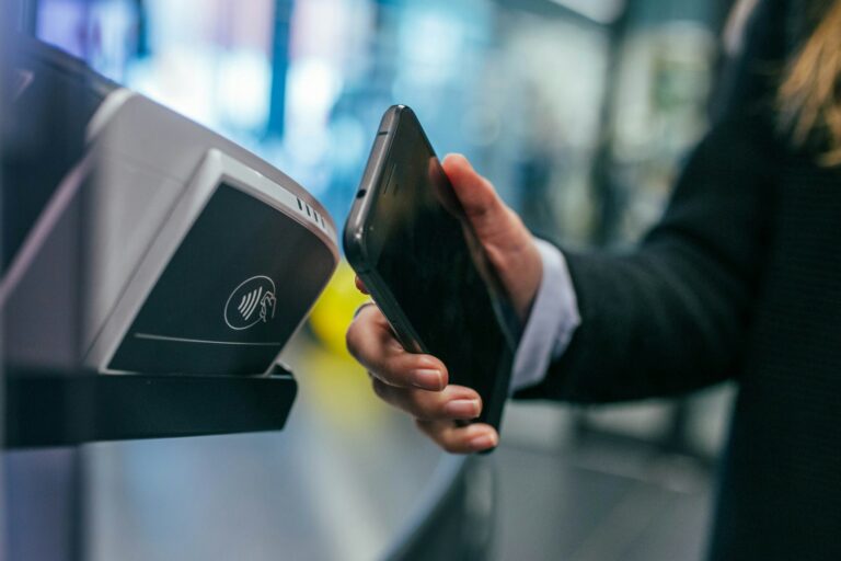 A person uses a smartphone for a safe, contactless payment at a terminal.