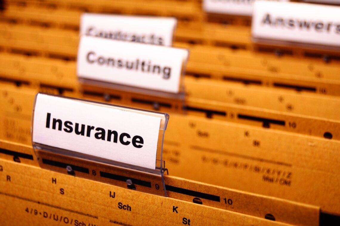 A close-up of organized file folders with labeled tabs, including "Life Insurance for Business Owners," "Consulting," and "Contracts," all arranged alphabetically in a streamlined filing system.