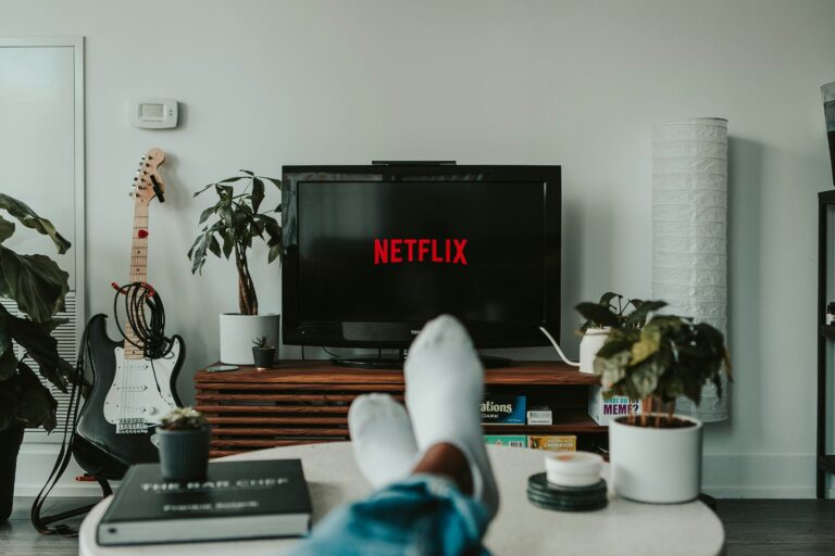 With feet up and Netflix on TV, this cozy living room is an oasis of relaxation. Amidst the greenery, a guitar, and a stack of books on a wooden coffee table, it's the perfect spot to unwind without adding to your entertainment expenses.